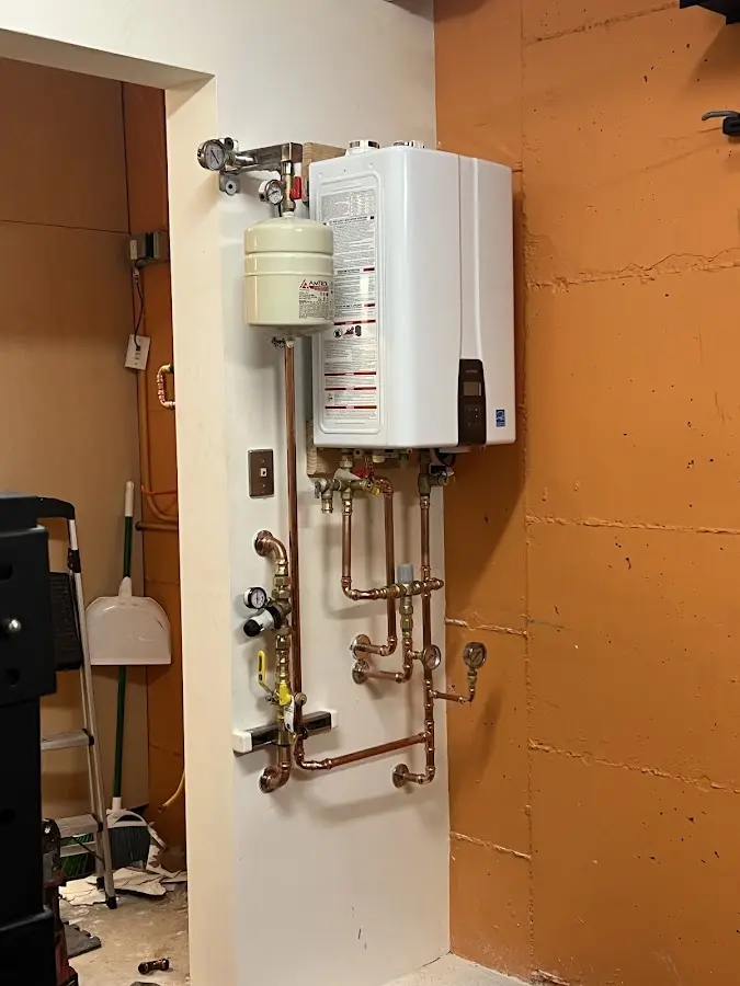 Plumbing technician inspecting water heater connections in West Norriton